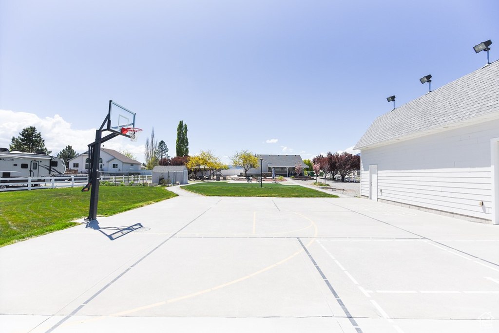View of patio featuring fence, a residential view, and basketball hoop
