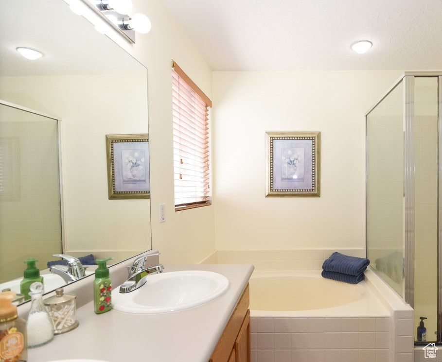 Bathroom featuring double vanity, a shower stall, a sink, and a bath