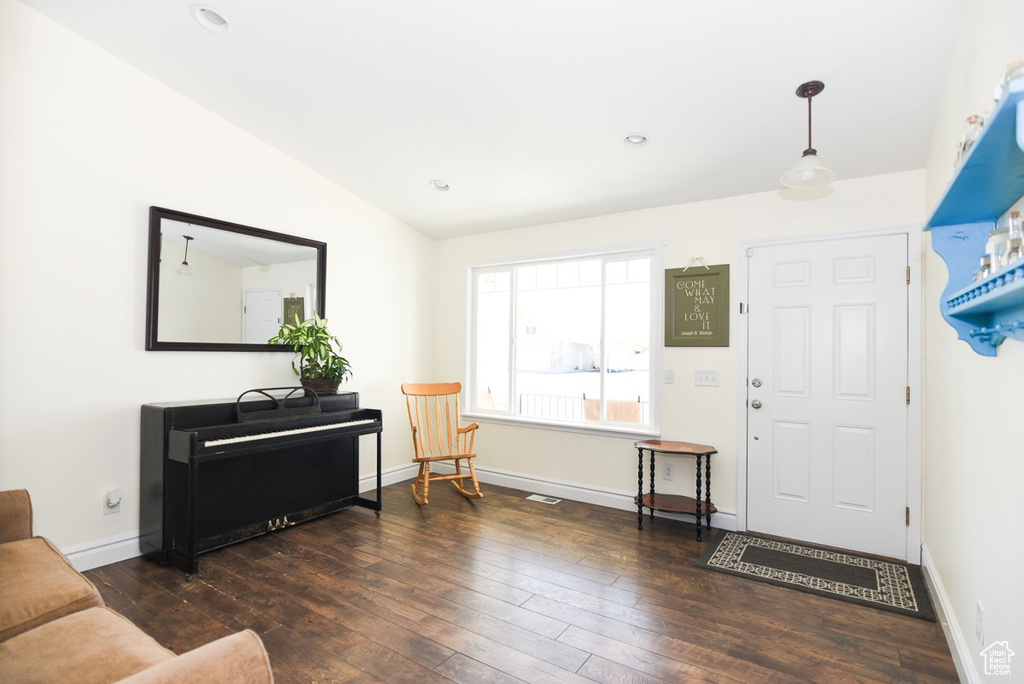 Foyer featuring baseboards, vaulted ceiling, and hardwood / wood-style flooring