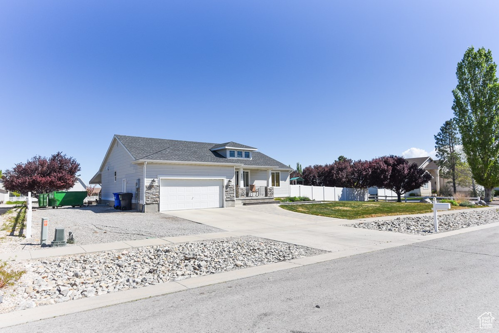 Traditional-style house featuring a garage, fence, and driveway