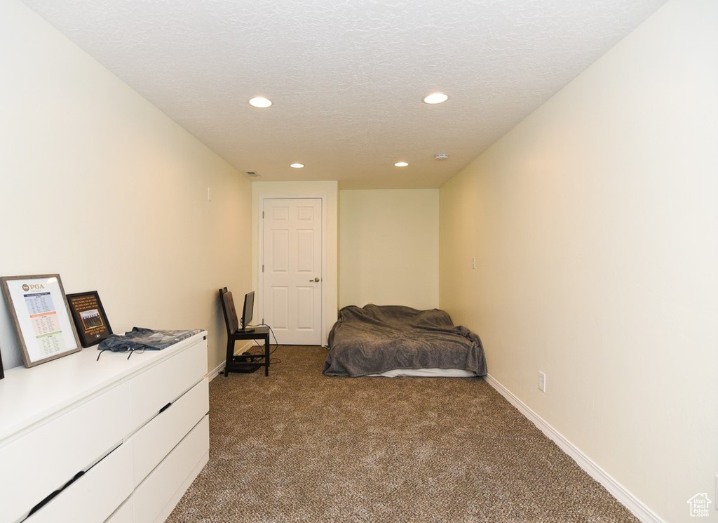 Bedroom featuring dark carpet, recessed lighting, baseboards, and a textured ceiling