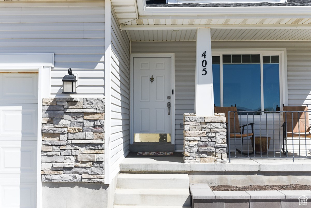 Entrance to property featuring covered porch and stone siding