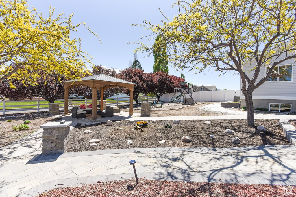 View of community with a gazebo, fence, and playground community
