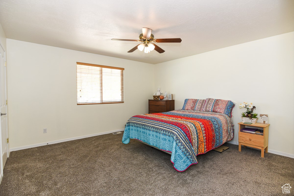 Bedroom with baseboards, ceiling fan, and carpet
