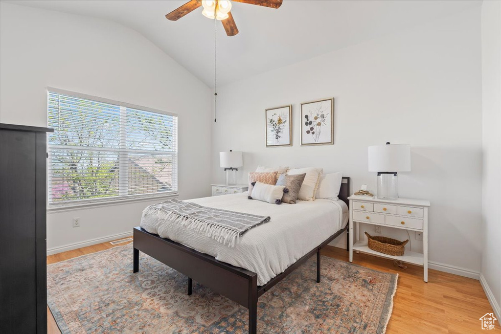 Bedroom featuring baseboards, ceiling fan, light wood-style flooring, and lofted ceiling