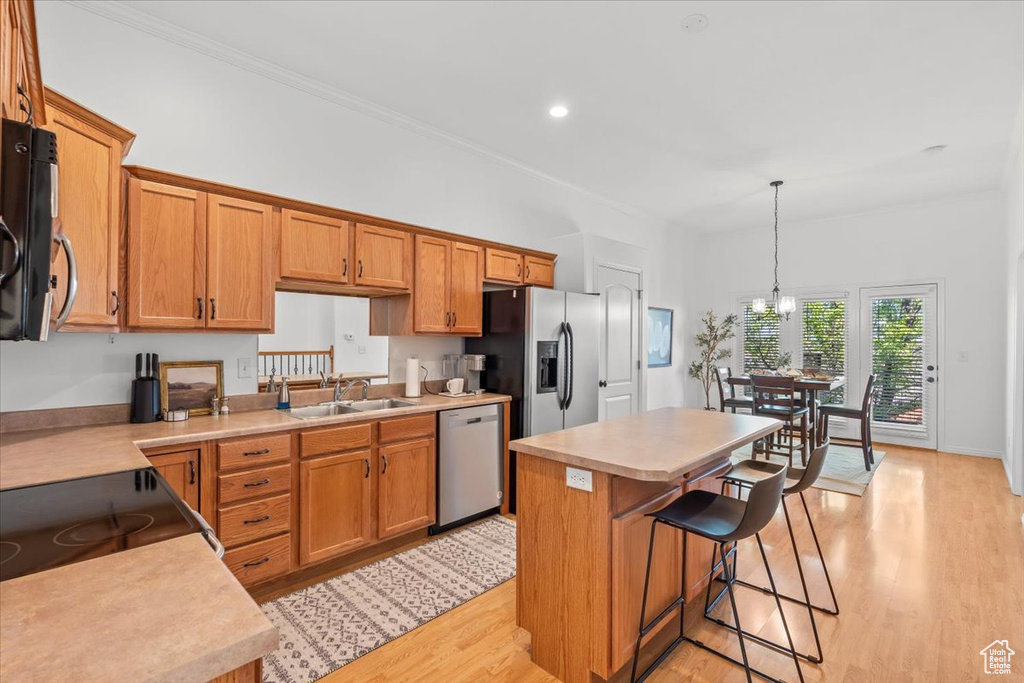 Kitchen featuring light wood-style floors, light countertops, a center island, and stainless steel appliances