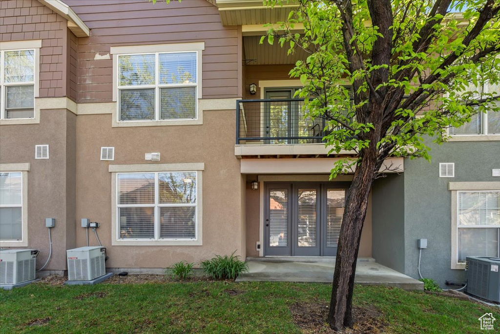 Back of property with french doors, central air condition unit, and a balcony