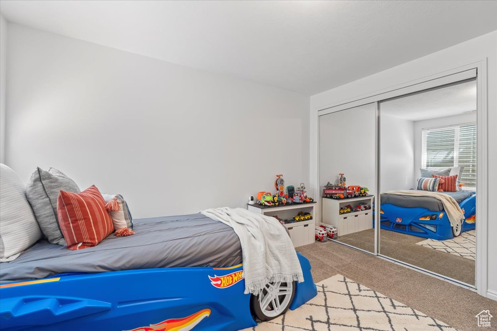 Bedroom featuring carpet and a closet