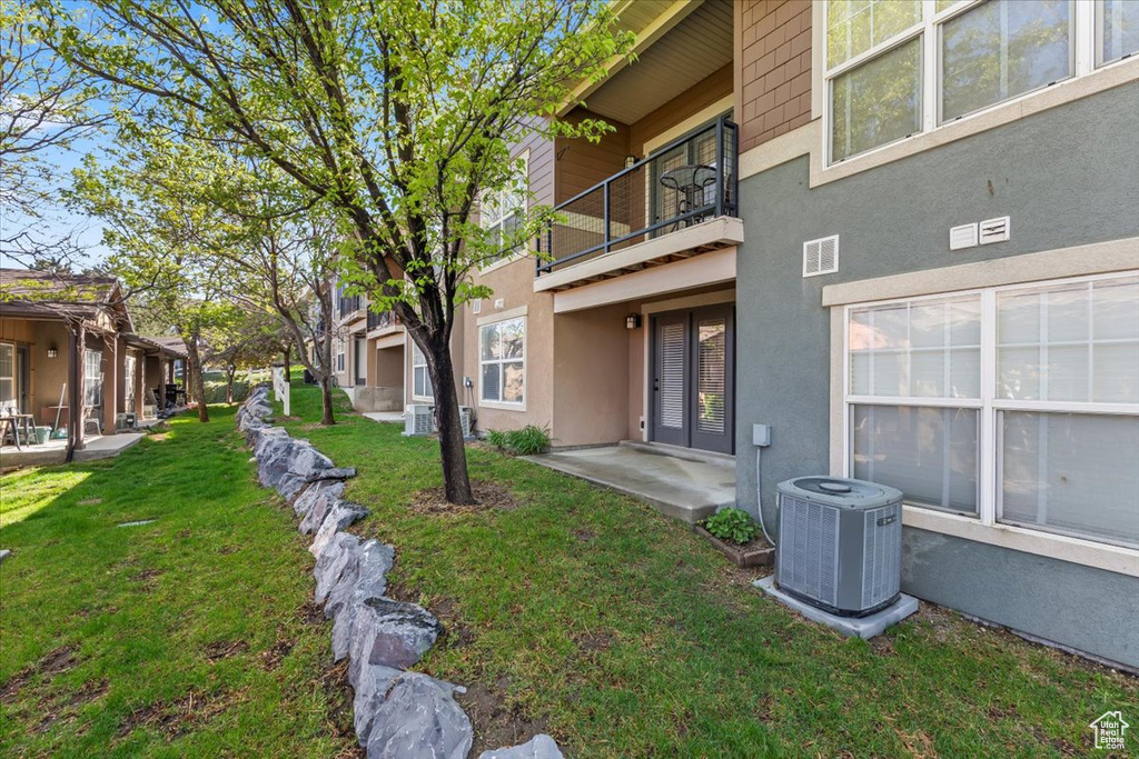 View of yard with visible vents, cooling unit, a patio area, and a balcony