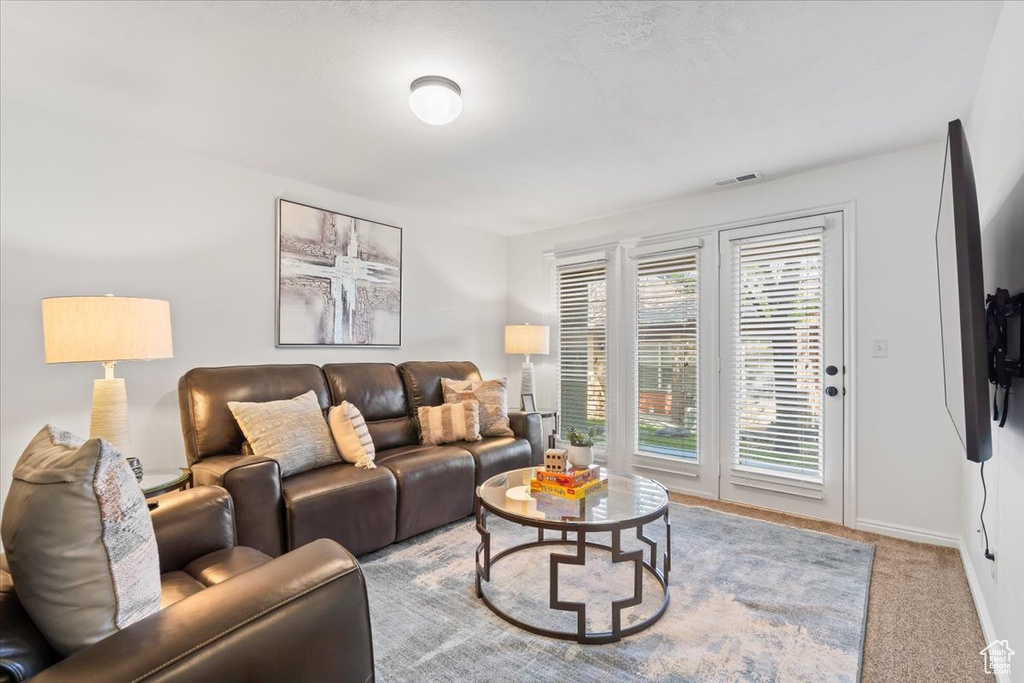 Living area with visible vents, carpet flooring, and baseboards