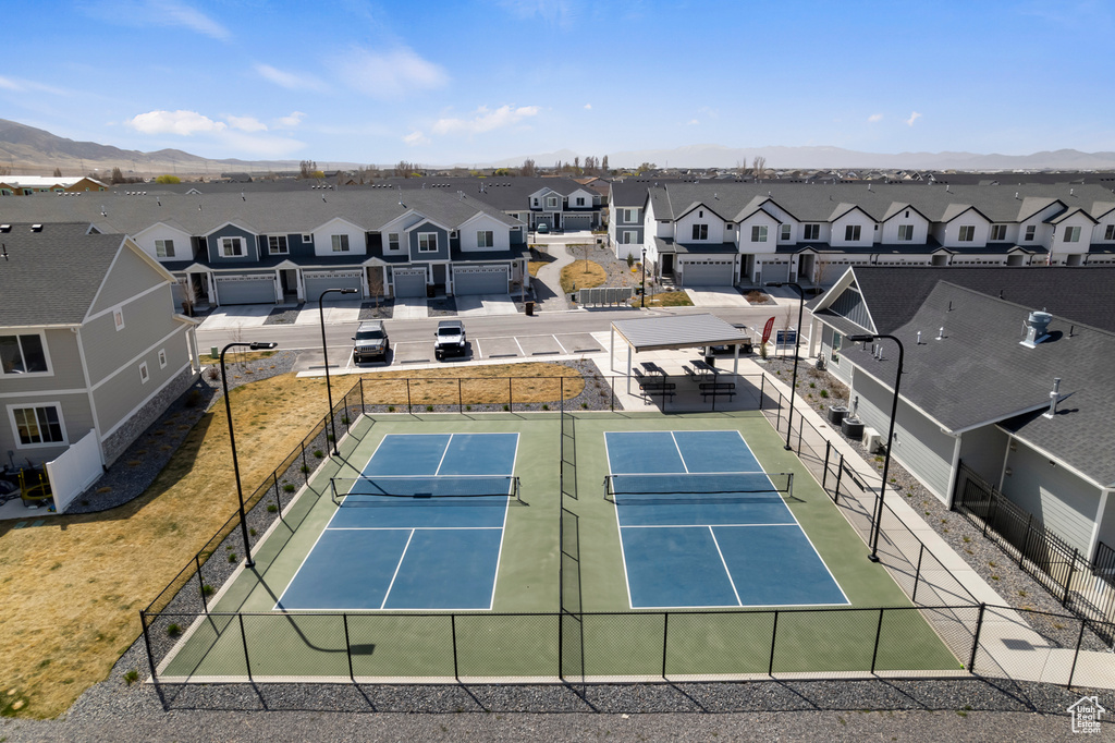 View of sport court with fence, a residential view, and a mountain view