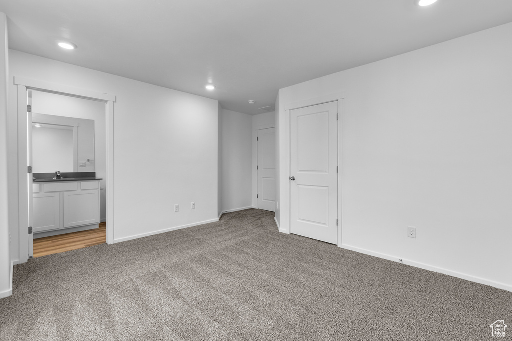 Interior space with a sink, carpet flooring, and recessed lighting