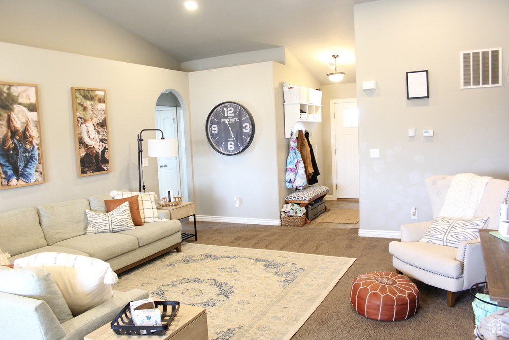 Living room with lofted ceiling and dark carpet