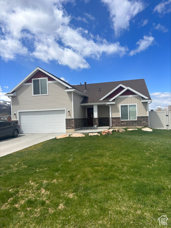 View of front of house with a garage and a front lawn
