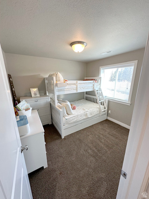 Carpeted bedroom featuring a textured ceiling