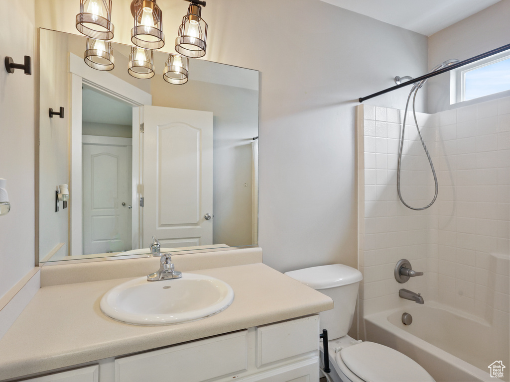 Full bathroom featuring toilet, a notable chandelier, bathtub / shower combination, and vanity