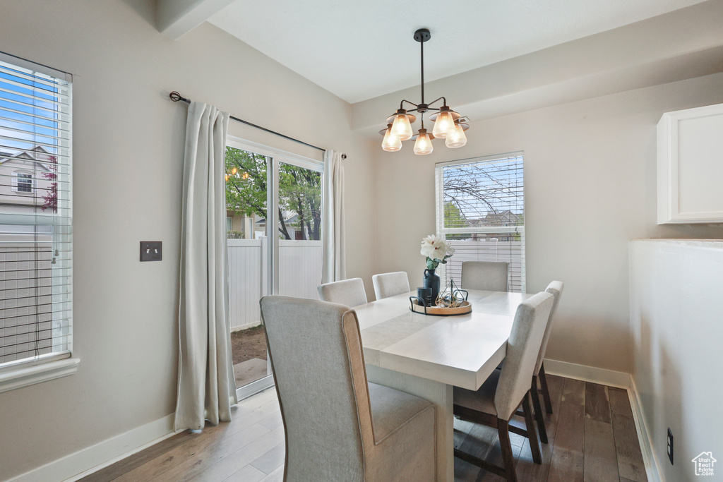 Dining room featuring baseboards, a chandelier, and wood finished floors
