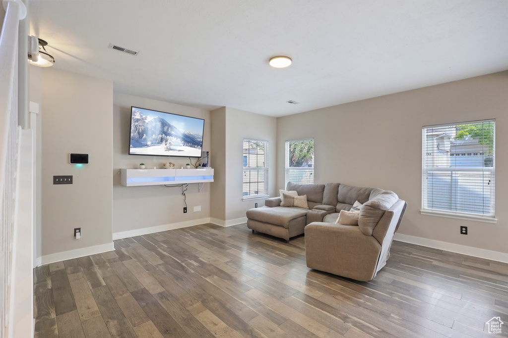Living room with wood-type flooring, baseboards, and visible vents