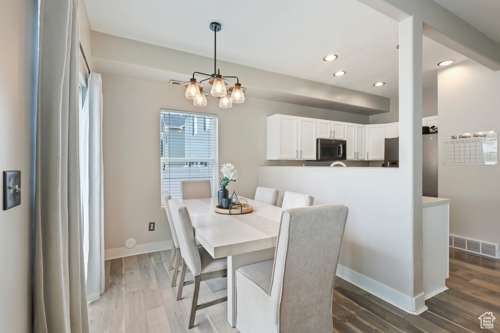 Dining room with recessed lighting, baseboards, a notable chandelier, and wood finished floors