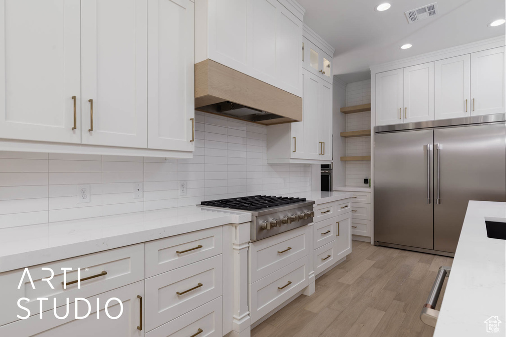 Kitchen featuring appliances with stainless steel finishes, white cabinets, decorative backsplash, open shelves, and recessed lighting