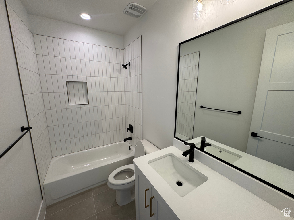 Bathroom with visible vents, tile patterned floors, vanity, toilet, and washtub / shower combination