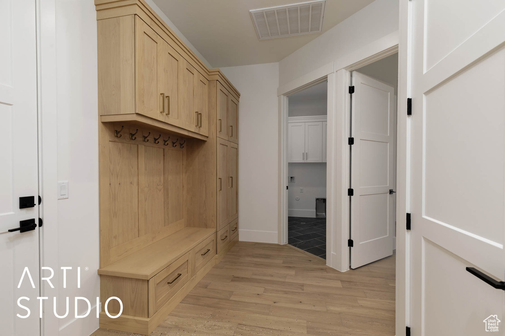 Mudroom with light wood-style flooring and baseboards