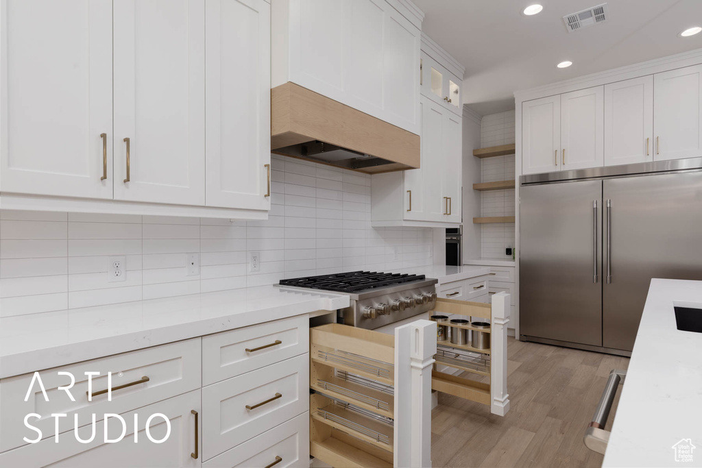 Kitchen featuring appliances with stainless steel finishes, open shelves, white cabinets, recessed lighting, and decorative backsplash