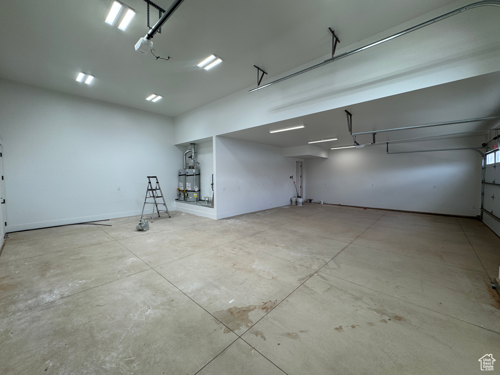 Garage featuring water heater and baseboards