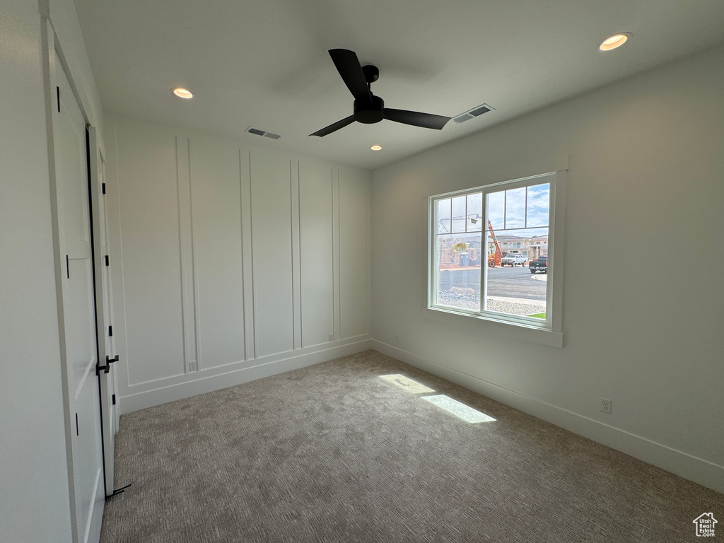 Carpeted spare room featuring ceiling fan, recessed lighting, and visible vents