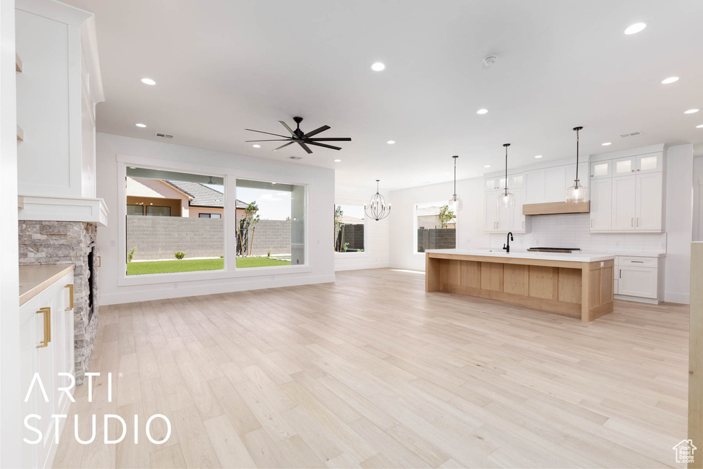 Kitchen with open floor plan, tasteful backsplash, a sink, recessed lighting, and light countertops