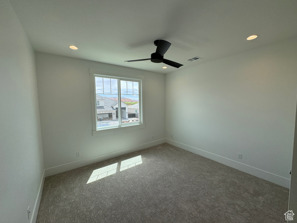 Carpeted empty room featuring baseboards, recessed lighting, ceiling fan, and visible vents