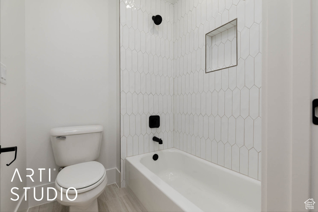Full bath with toilet, shower / bathtub combination, and baseboards