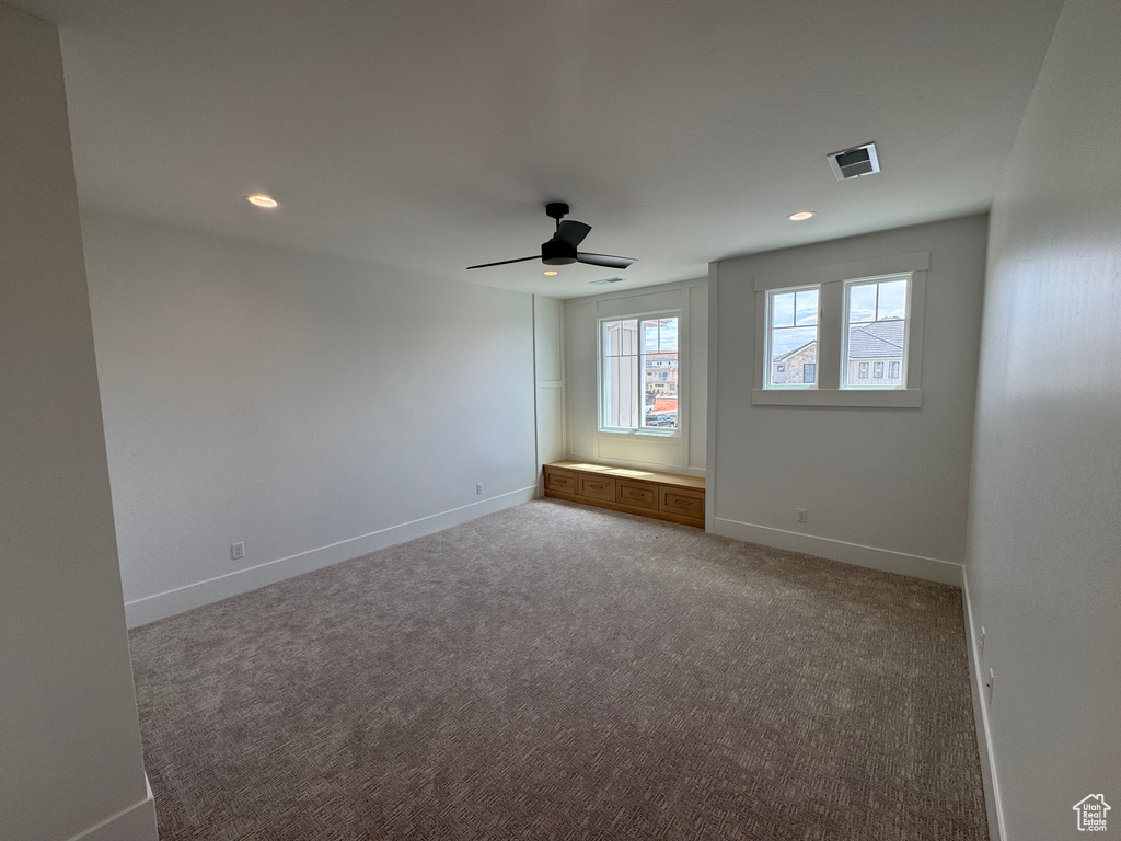 Carpeted empty room with a ceiling fan, baseboards, recessed lighting, and visible vents