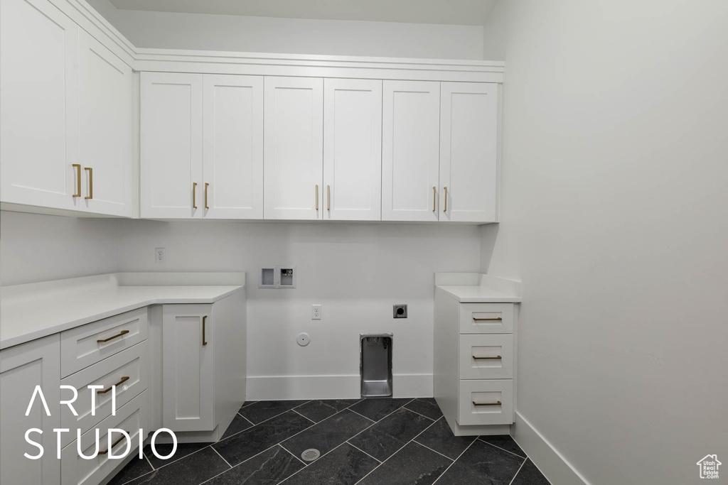 Laundry room with cabinet space, baseboards, hookup for a washing machine, and electric dryer hookup