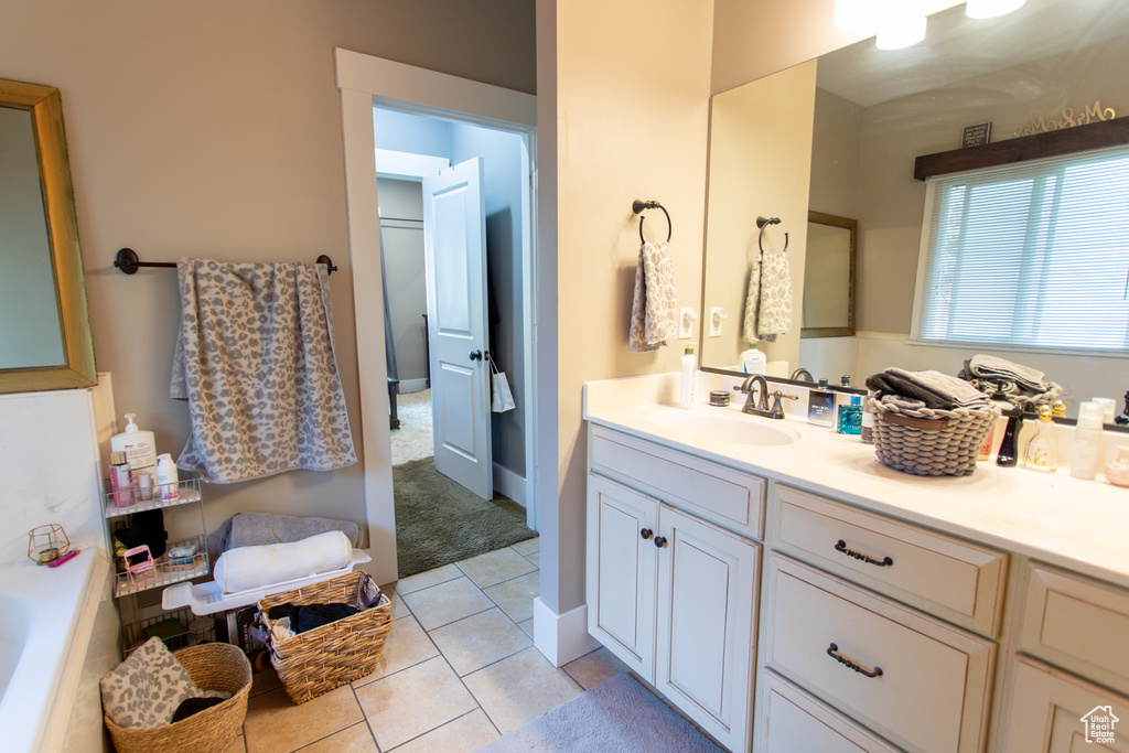 Bathroom with vanity, tile patterned floors, and a tub