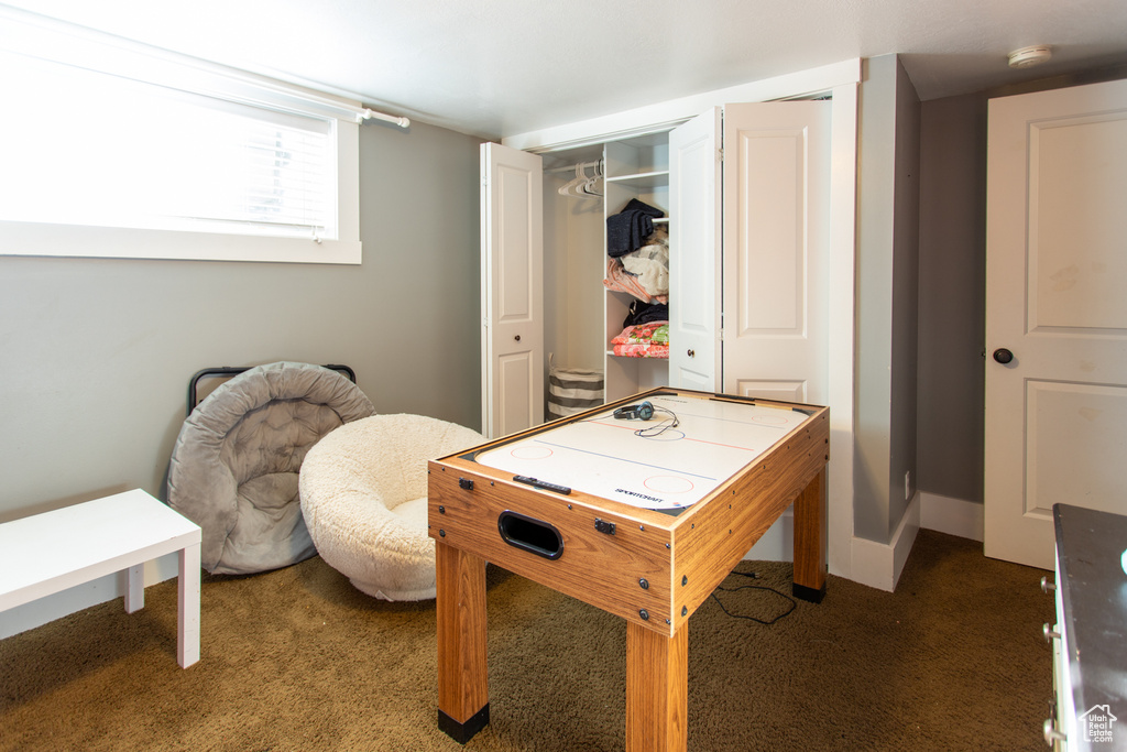 Recreation room featuring baseboards and carpet