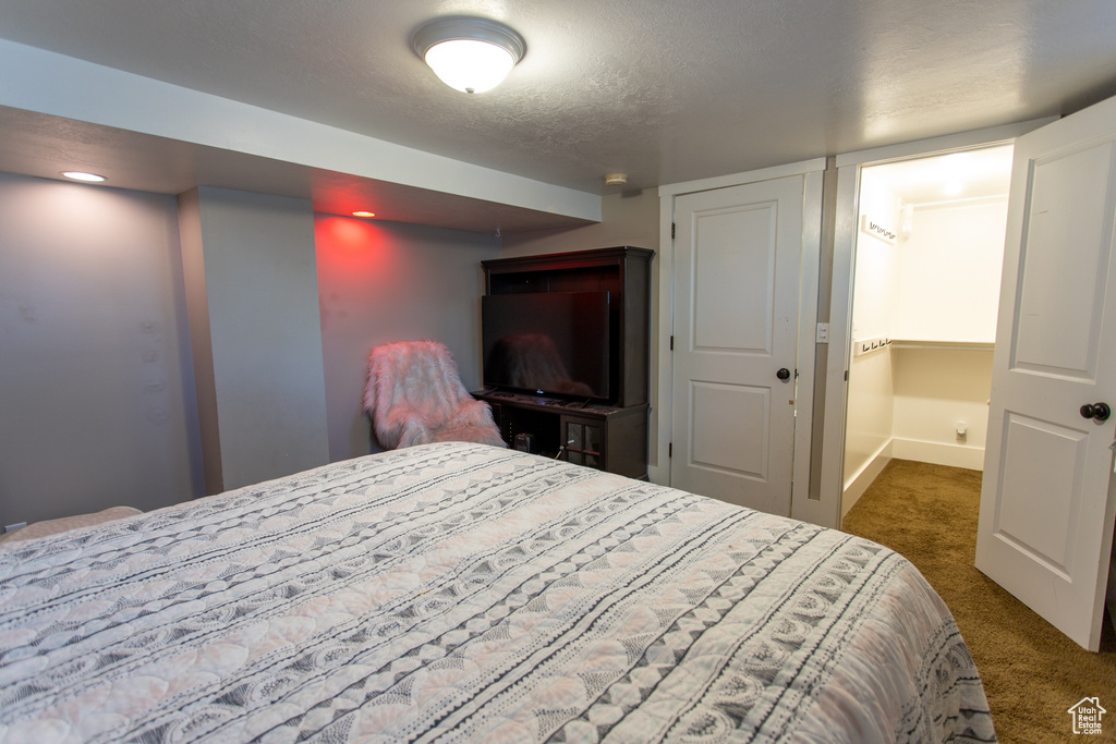 Bedroom featuring carpet flooring and a textured ceiling