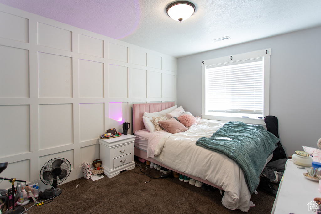 Bedroom featuring carpet floors, a textured ceiling, and visible vents