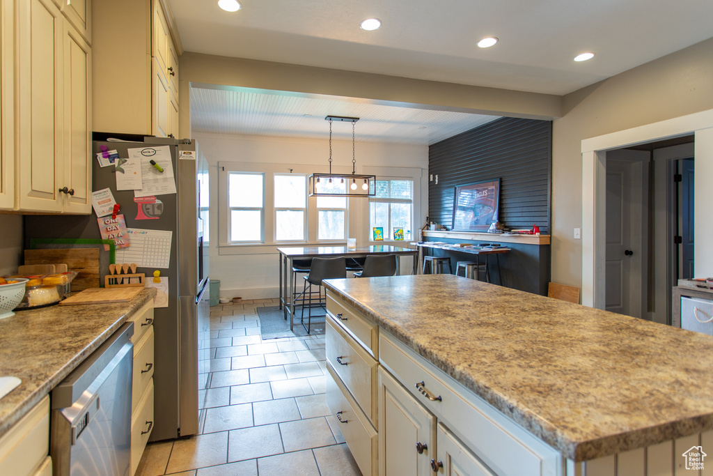 Kitchen with recessed lighting, appliances with stainless steel finishes, light tile patterned flooring, and a kitchen island