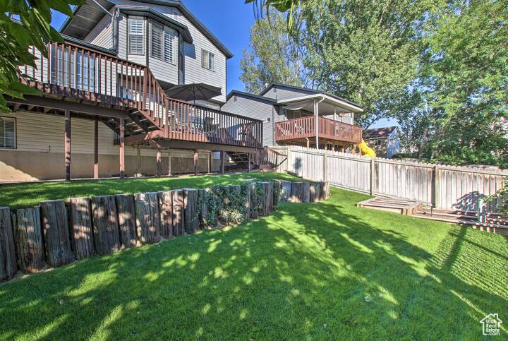 View of yard with a fenced backyard, a wooden deck, and stairway