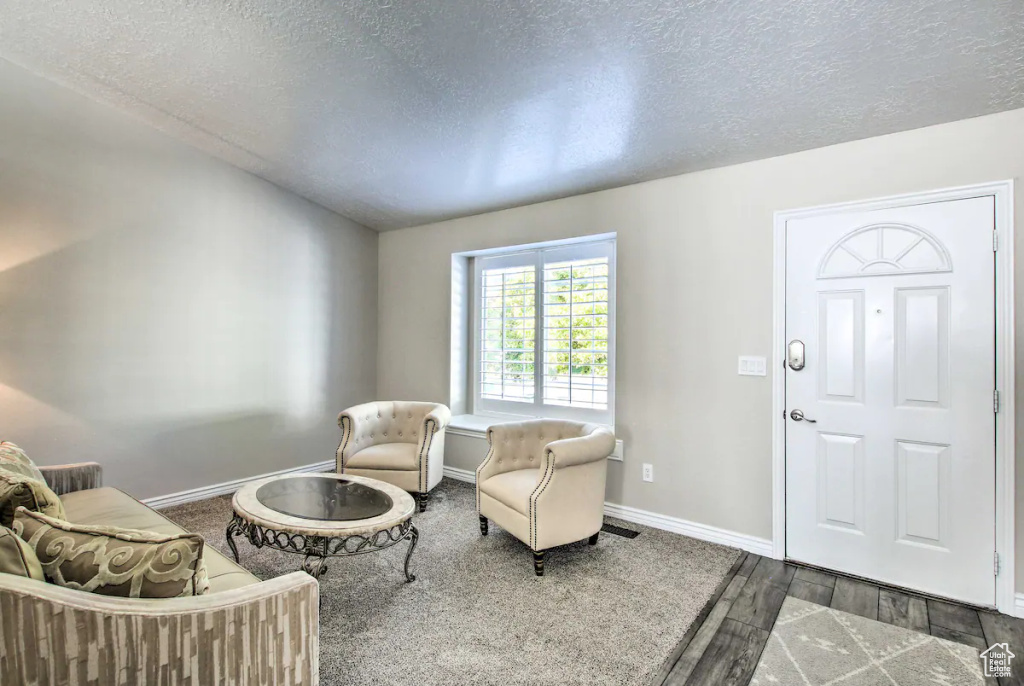 Entryway with wood finished floors, a textured ceiling, and baseboards