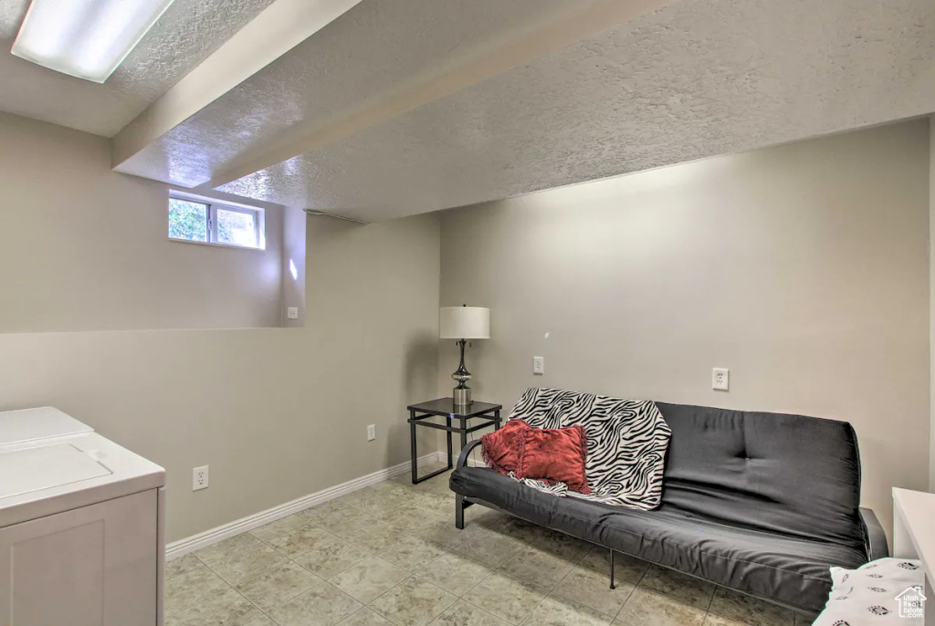 Living area featuring washer and dryer, baseboards, and a textured ceiling