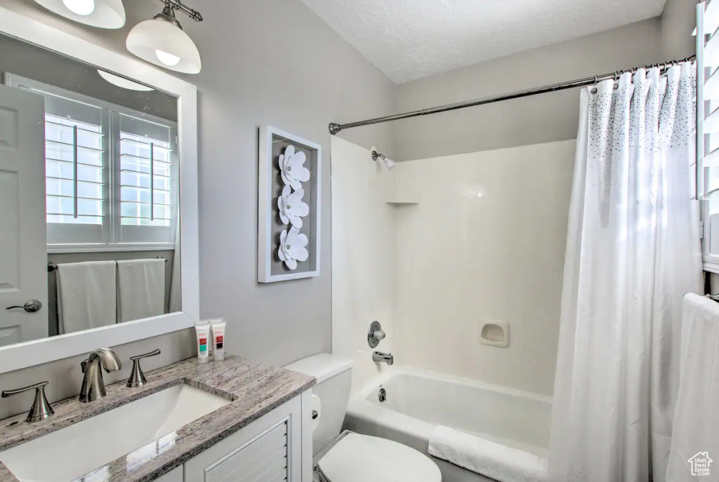 Full bath featuring shower / tub combo, vanity, and toilet