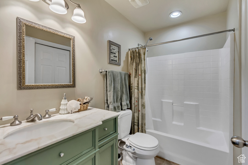 Bathroom with toilet, visible vents, shower / bath combination with curtain, and vanity