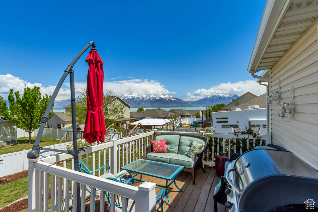Wooden terrace with a residential view, fence, a mountain view, and area for grilling