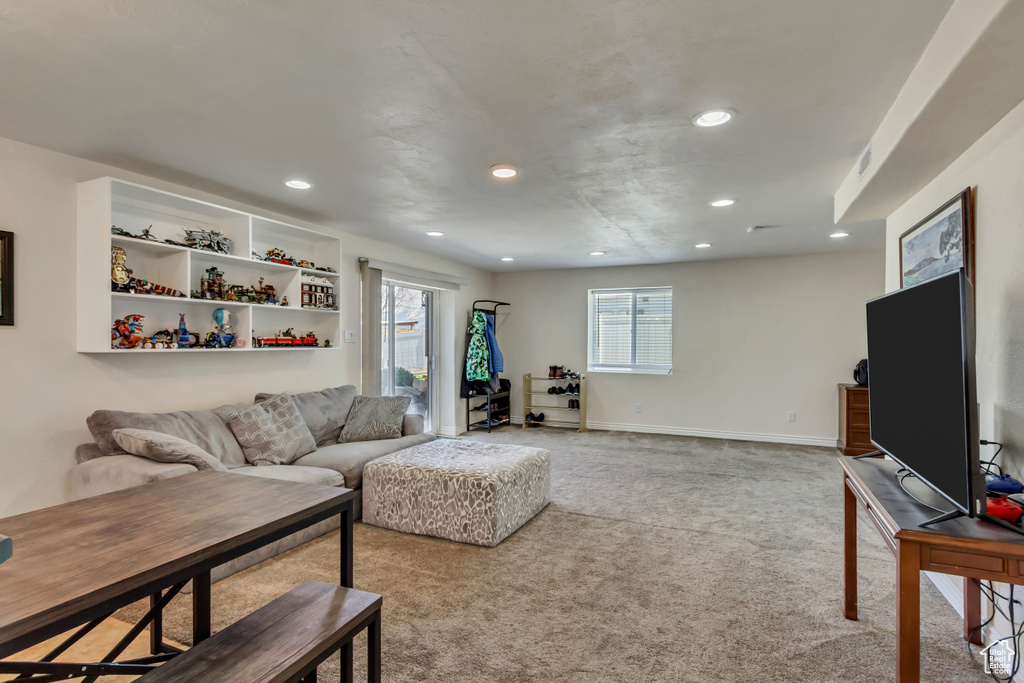 Carpeted living room featuring recessed lighting and baseboards