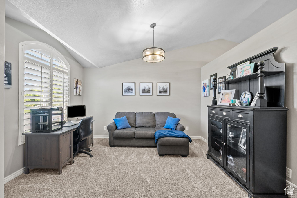 Office area with light colored carpet, baseboards, and vaulted ceiling
