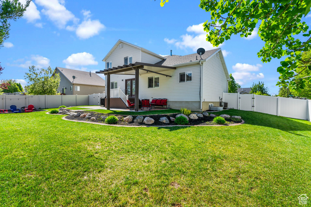 Back of property with a lawn, a patio, a gate, and a fenced backyard