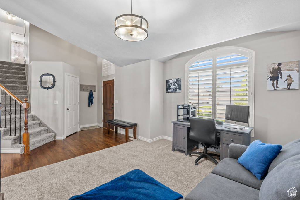 Office featuring baseboards, carpet, vaulted ceiling, and wood finished floors