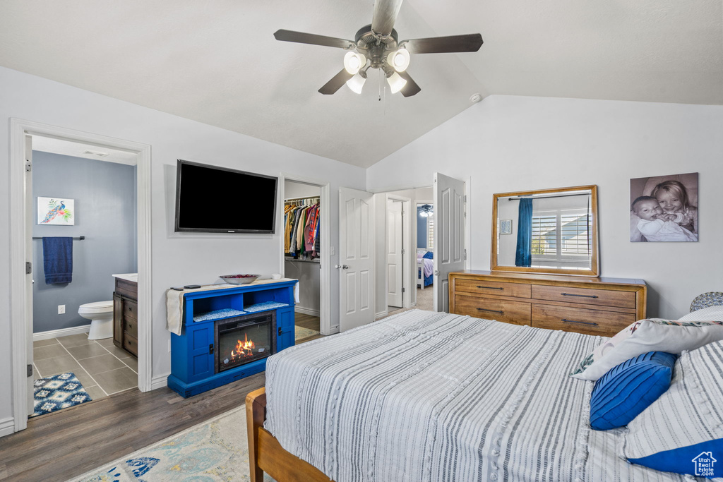 Bedroom with a closet, wood finished floors, a walk in closet, ensuite bath, and vaulted ceiling